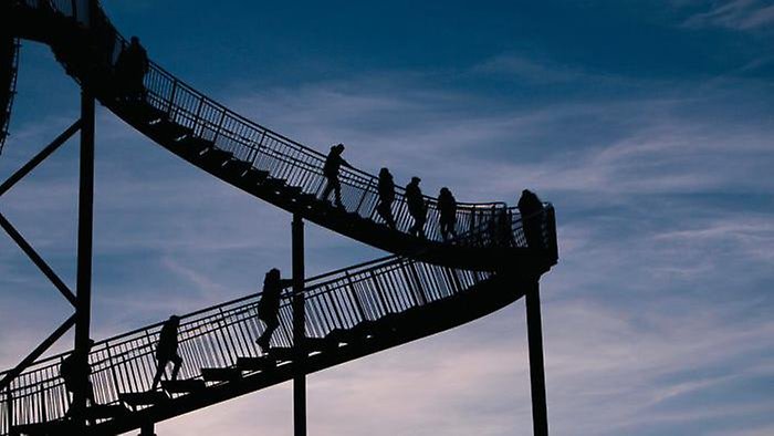 People walk on escalators at dusk